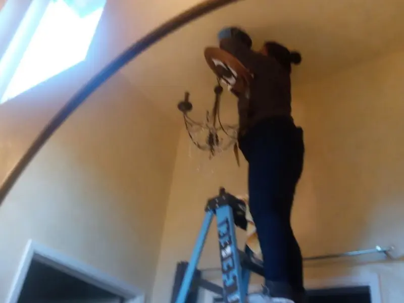 Electrician installing a chandelier in a Kirkwood residence